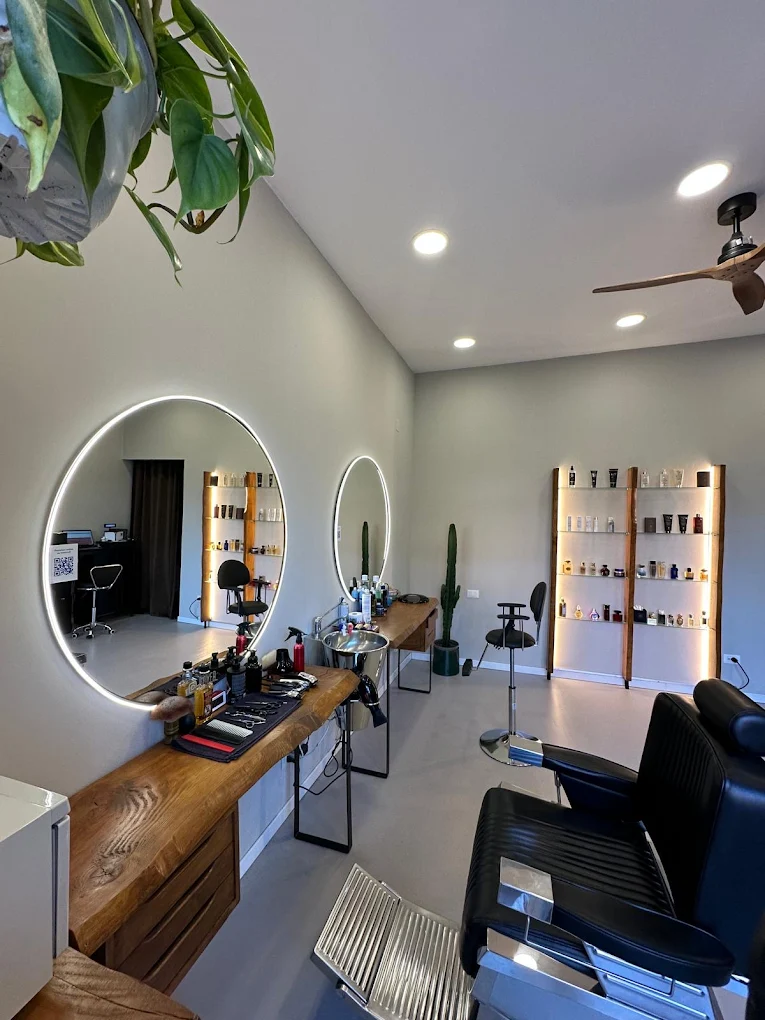 Estación de trabajo moderna en Feivèr Barber Treviglio con exhibición de productos y acabados en madera.